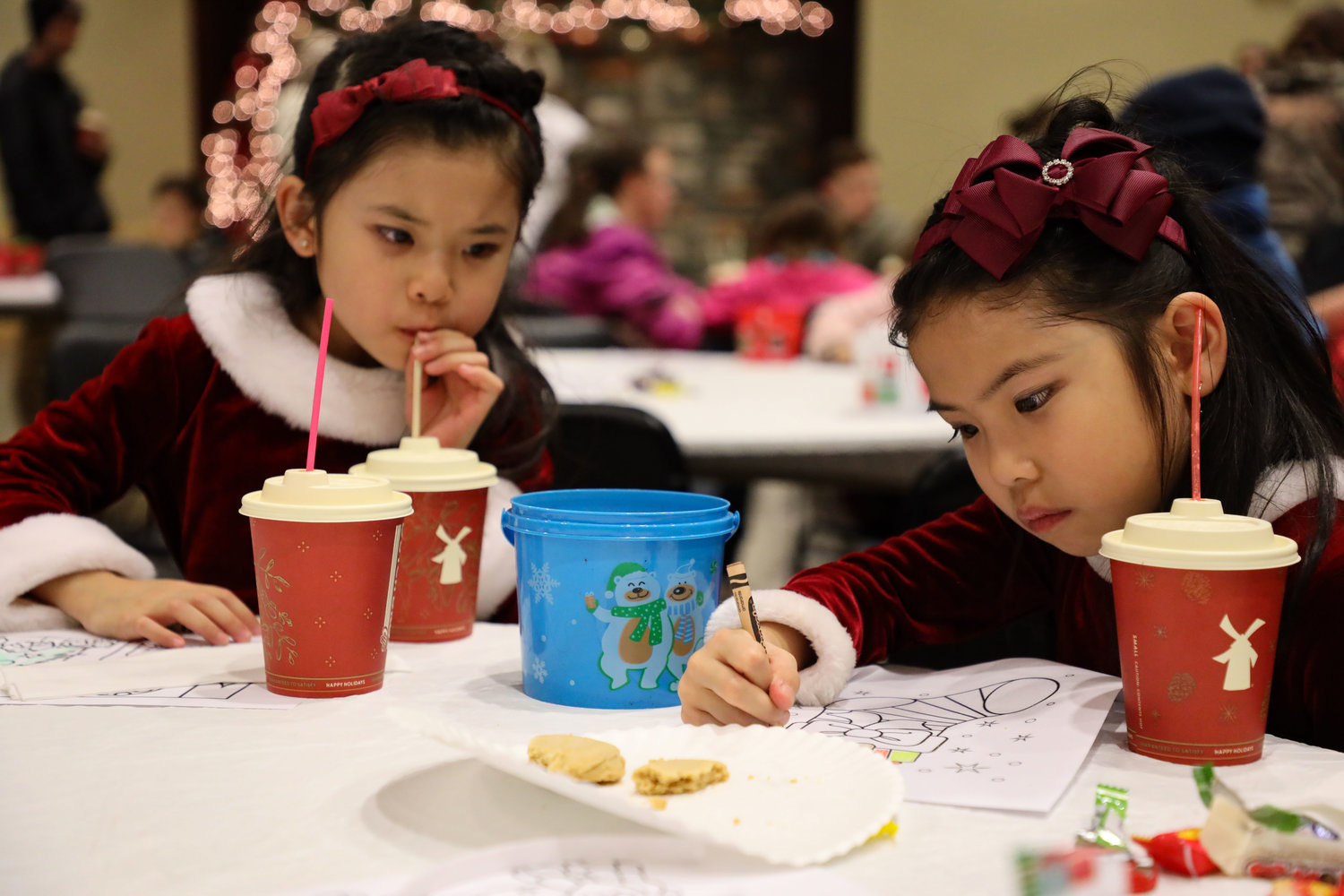 From left to right, 5-year old Victoria Chu and 7-year-old Jasmine Chu, of Battle Ground, enjoy hot cocoa, cookies and coloring during the annual tree lighting at the Battle Ground Community Center.