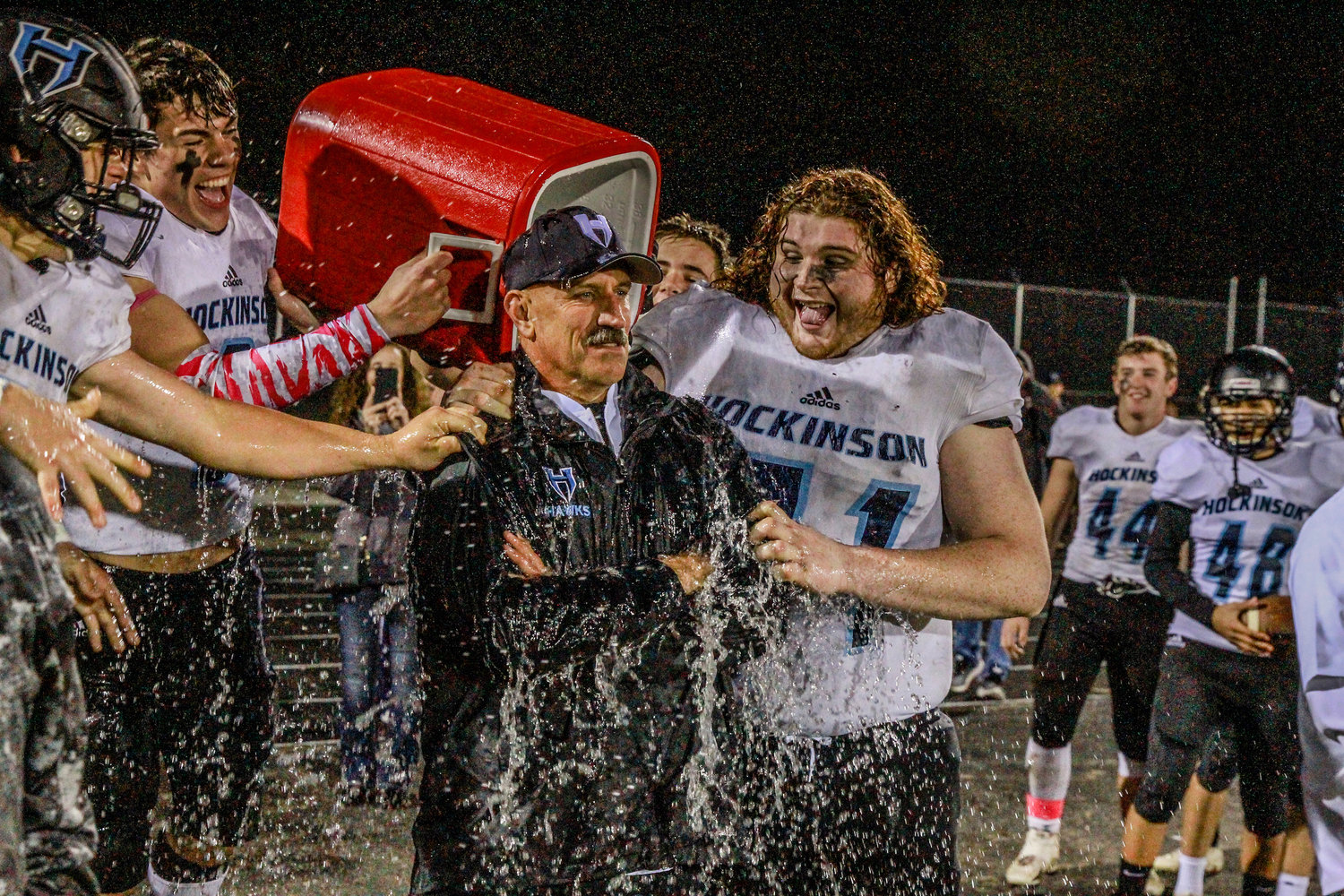 Hockinson players douse head coach Rick Steele to celebrate his 100th win with the program.  
