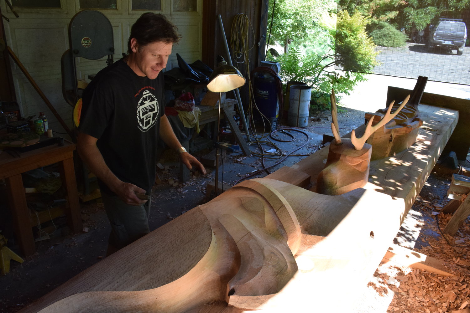 La Center woodcarver Adam McIsaac talks about the content of a story pole he is carving for the Puyallup tribe at his workshop Sept. 4.