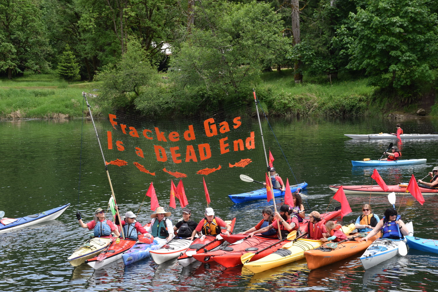 Kayakers on the Kalama River hold a banner stating opposition against a proposed methane-to-methanol facility in Kalama during a protest May 18.