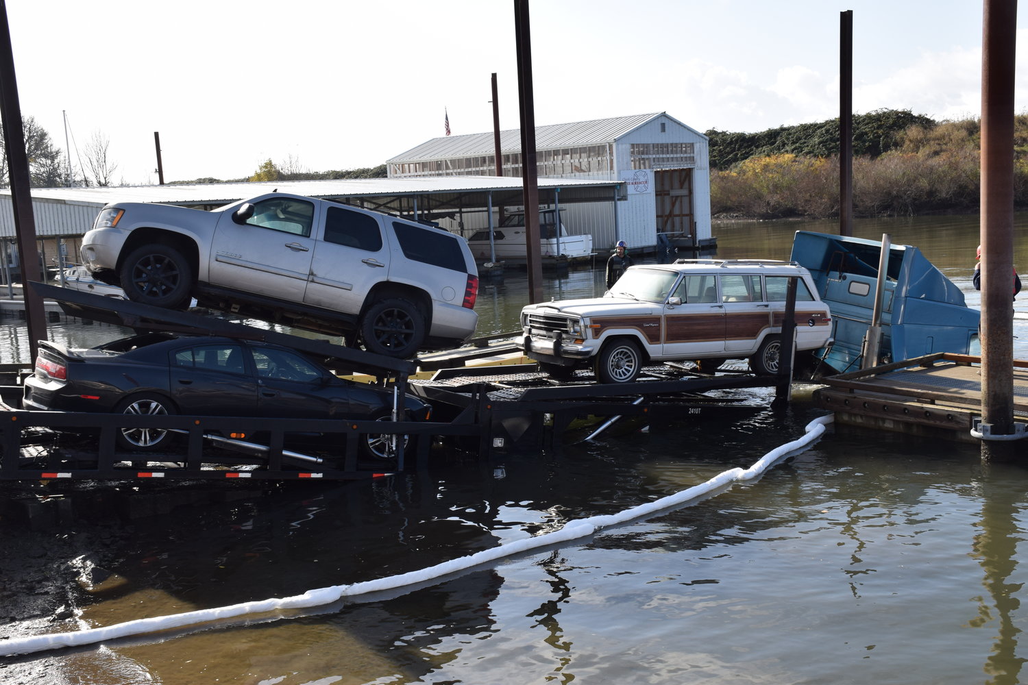 A semi-trailer carrying passenger vehicles sits partially in Lake River at the Ridgefield boat launch following a train striking the stalled-out trailer on tracks this morning. 