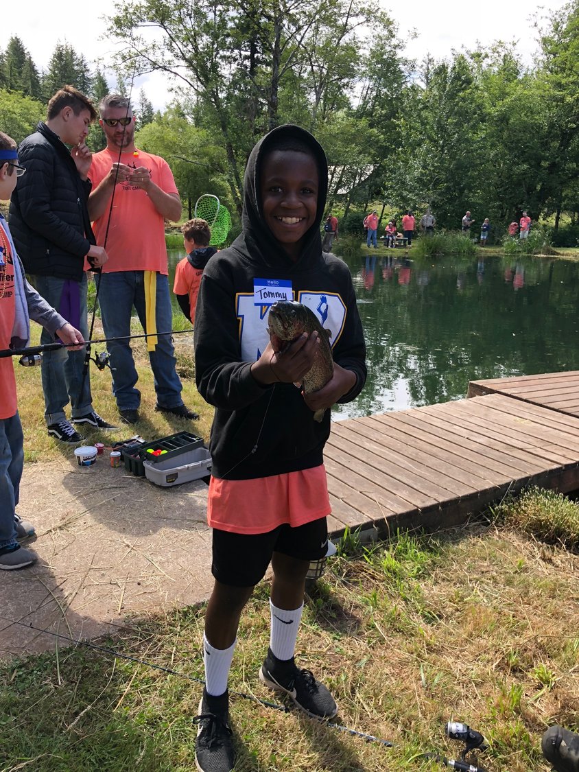 A young angler holds up a fish he pulled in at Faith Outfitters’ fishing event held on Father’s Day. 