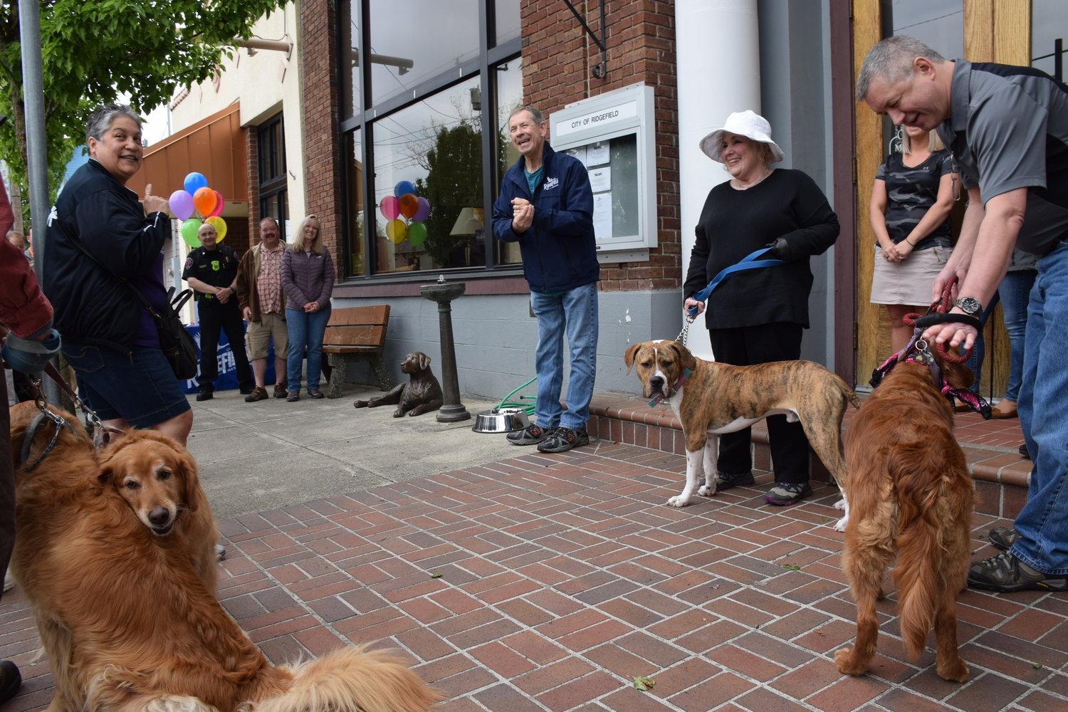 Ridgefield Mayor Don Stose speaks to those gathered, both citizen and canine, for the unveiling of a donated bronze sculpture of a golden retriever donated by former mayor and community leader Tevis Laspa during a ceremony May 4.