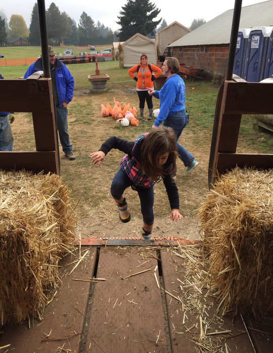 Grace Negrov, 4, of Battle Ground, climbs aboard a hayride to the pumpkin patch. 