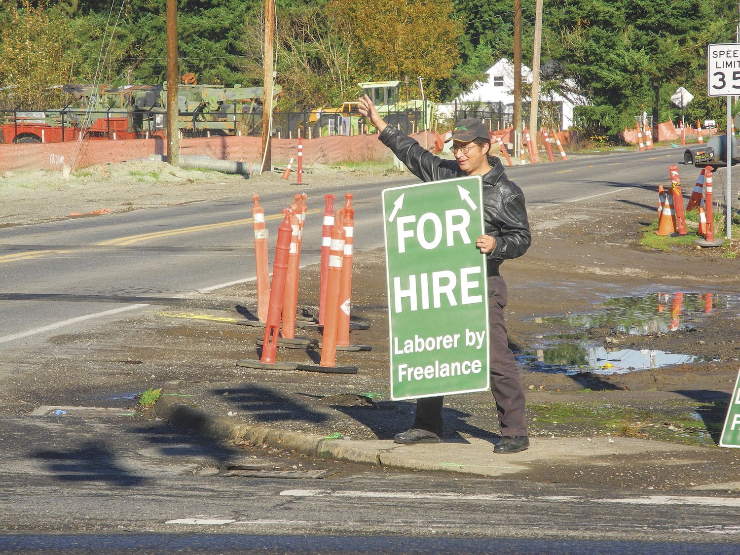 FREELANCE LABORER Lopez takes his usual place at the Dollars Corner intersection as he advertises for work.