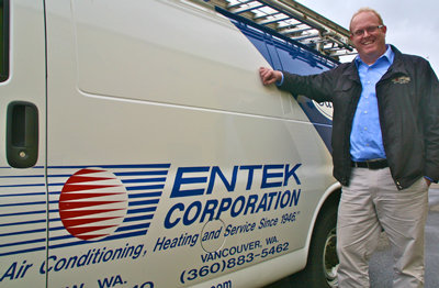 ENTEK’S CHRIS MCKINNEY with one of the company’s vans. Pressurized vinyl acetate polymer is pumped into a sealed heating/ventilation/air cooling system, and reduces leaks in the system. The process is monitored by a computer and gives real-time leakage reduction information. Photo courtesy of FH Browne.