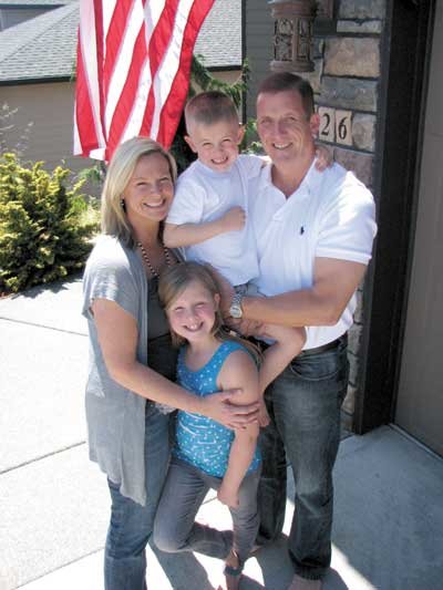LORI AND RANDY
VOLKMAN with their children, Copper and Olivia, stand outside their
Ridgefield home the day before Randy returned to the Middle
East.