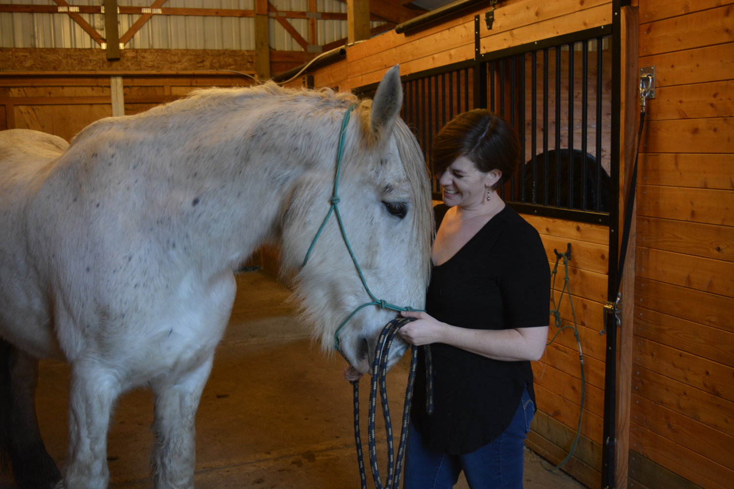 Meghan Hindi stands with a therapy horse, Avalon. The duo work together as a part of The Healing You Can Do program for trauma survivors.