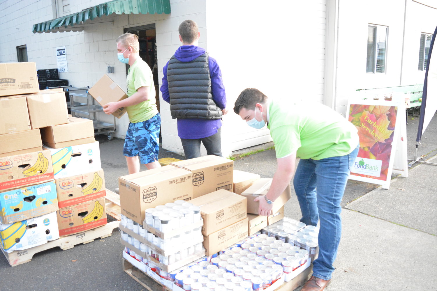 Volunteers unpack a large pallet of food at the North County Community Food Bank on Thursday, Nov. 17.