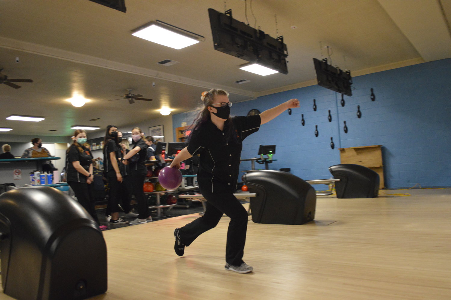 Sydney Wheaton is pictured making a shot in bowling as her team looks on.