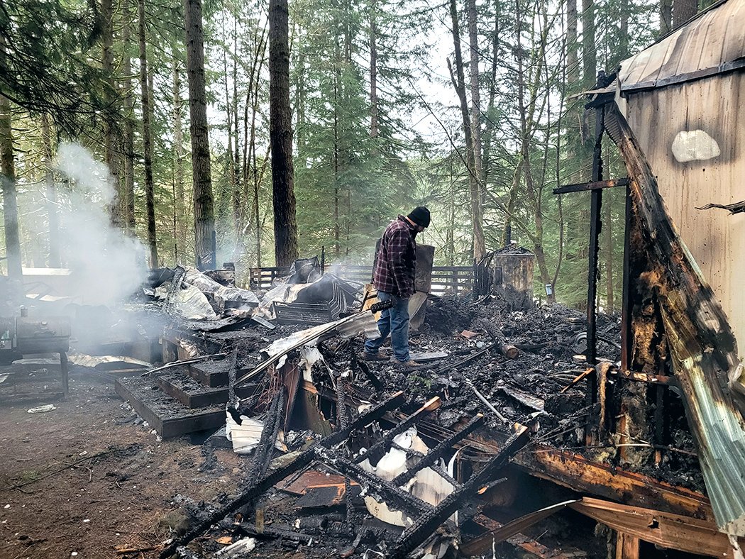 Toby Schultz observes the wreckage of his home that burnt down at Royal Ridges Retreat in Battle Ground.