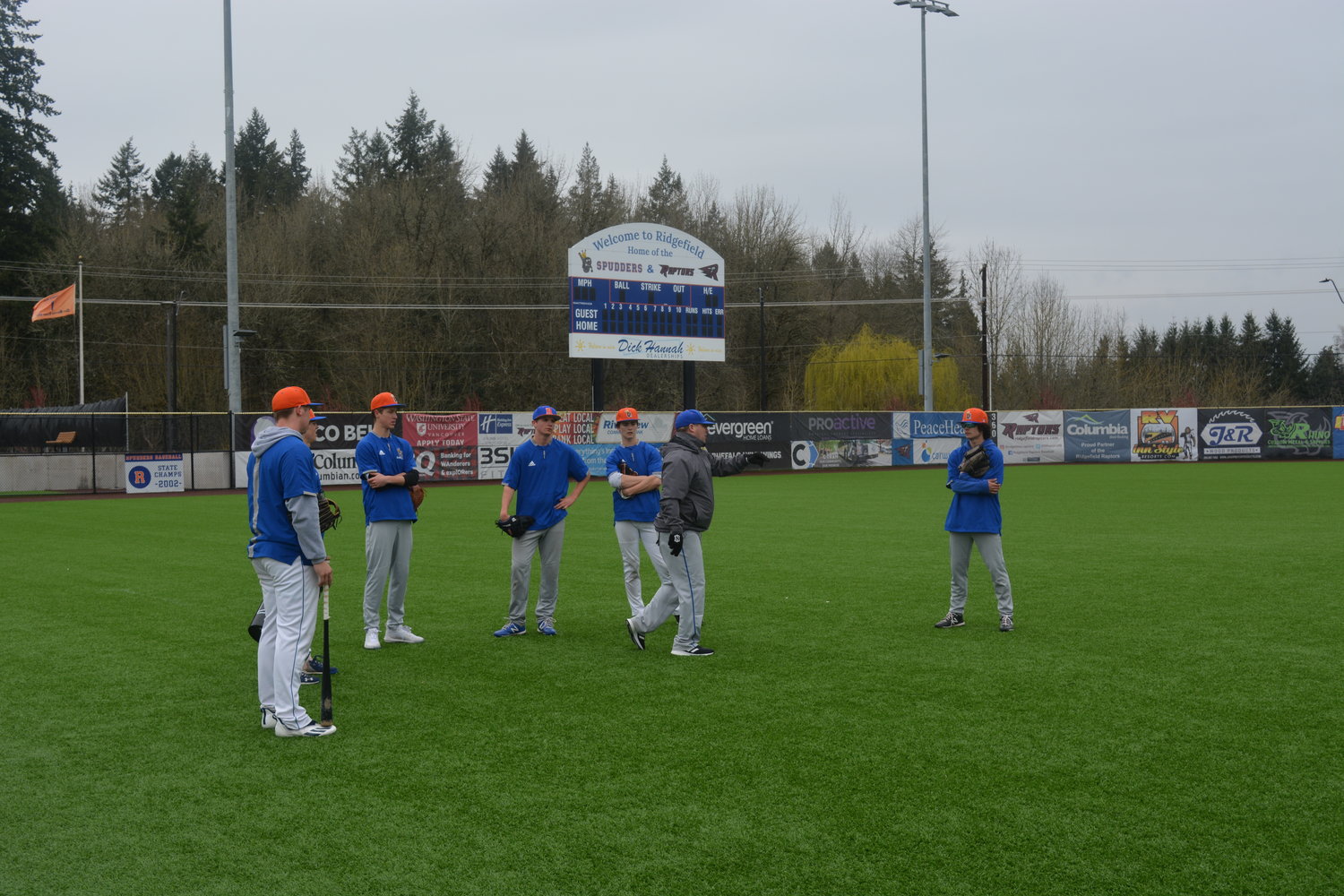 Coach Nick Allen instructs a number of players on the varsity baseball team during a March 17 practice at the Ridgefield Outdoor Recreation Complex in preparation for its game against Lynden High School.