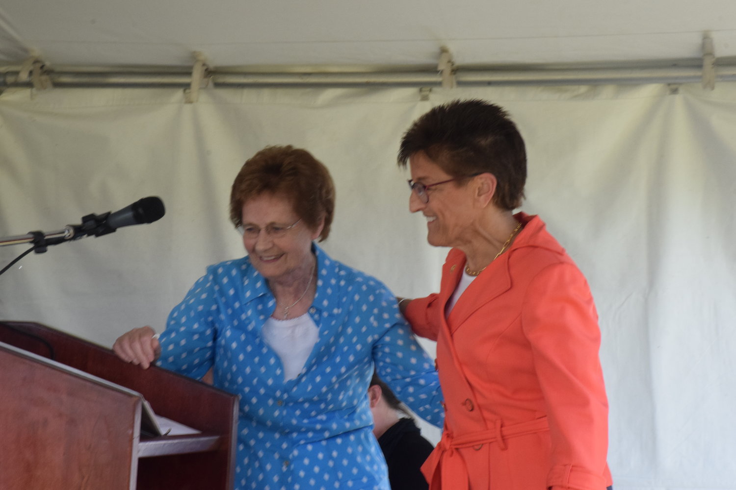 Outgoing Clark College Foundation CEO Lisa Gibert, right, turns the podium over to Bernice Boschma during a groundbreaking ceremony for Clark College at Boschma Farms June 1.