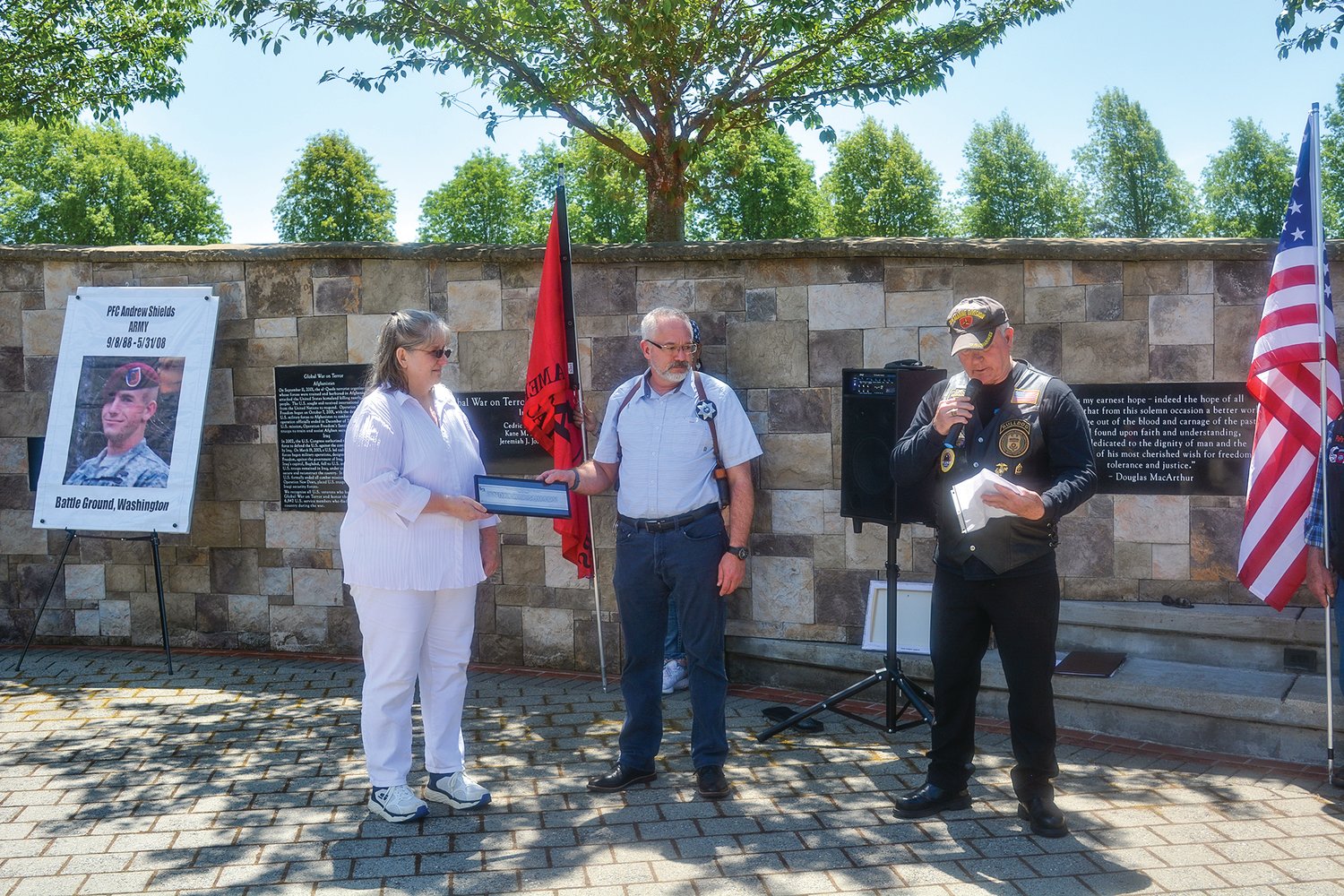 PFC Andrew Jon Shields’ parents, Wendy Campbell and Jon Shields, are presented with a plaque by Lynn Vaughn of the Patriot Guard Riders in honor of their son on May 31.