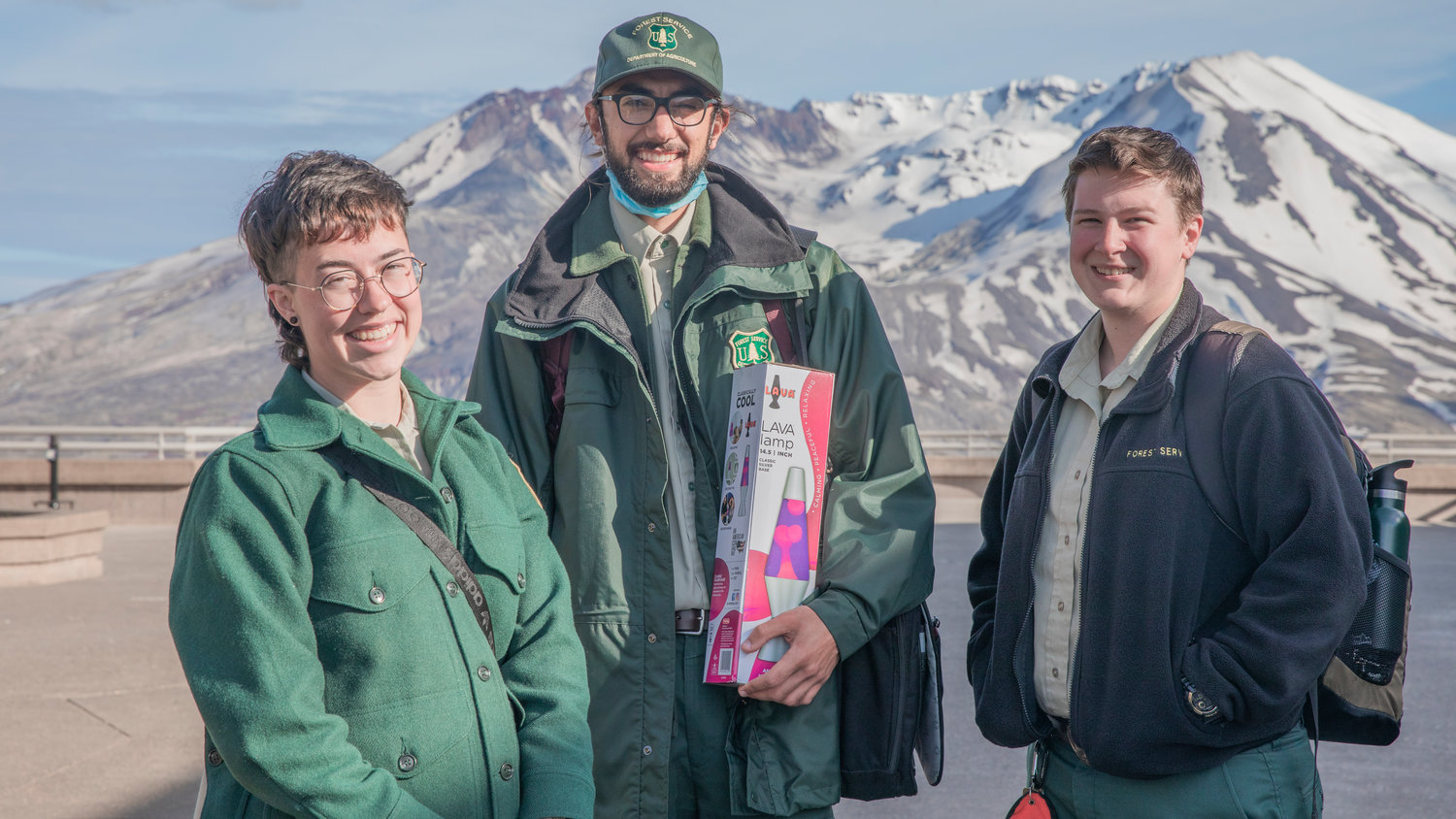 From left, Madisyn Emley, Nishan Mahdasian, and Skye Clark, Park Rangers at the Johnston Ridge Observatory smile for a photo in front of Mount St. Helens on June 8.
