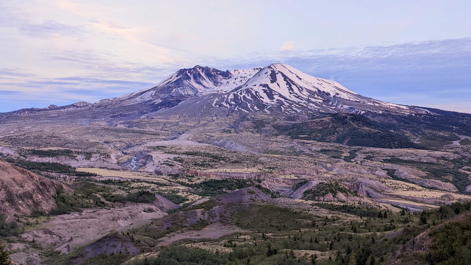 Mount St. Helens towers over the horizon at sunset.