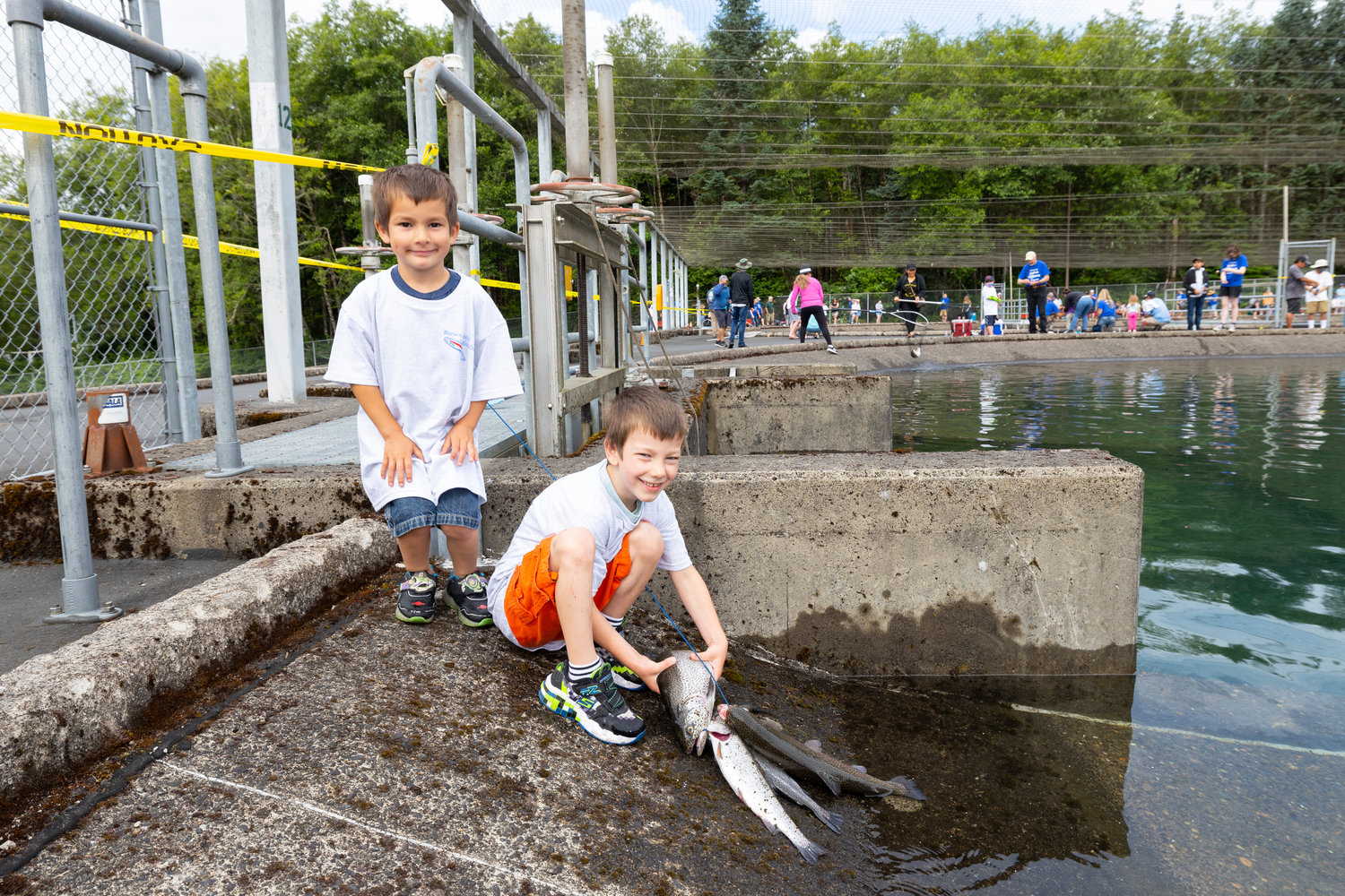 Kids show off rainbow trout that were caught at the Merwin Fish Hatchery in Woodland on July 9.