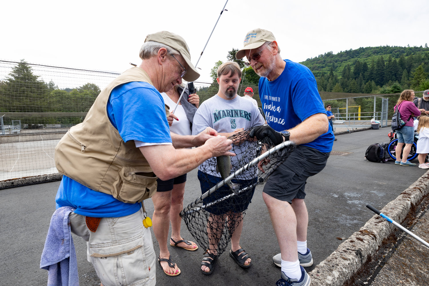 A volunteer helps unhook a fish caught during the Merwin Special Kids Day event in Woodland on July 9.