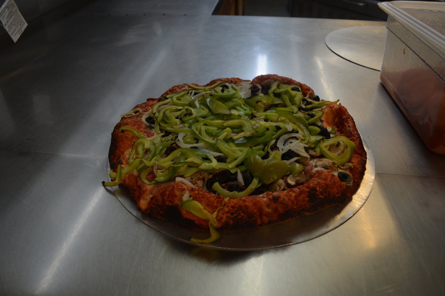 A pizza is decked out in peppers, olives, and mushrooms at Rocky’s Pizza & R Bar in Battle Ground on July 28.