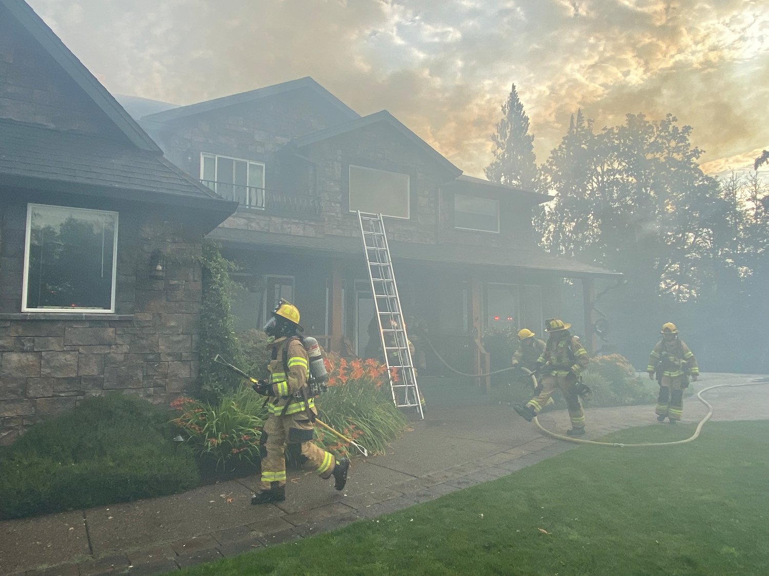 Firefighters work to extinguish a structure fire at a home in the 1400 block of Northwest 304th Circle in Ridgefield on Aug. 1. 