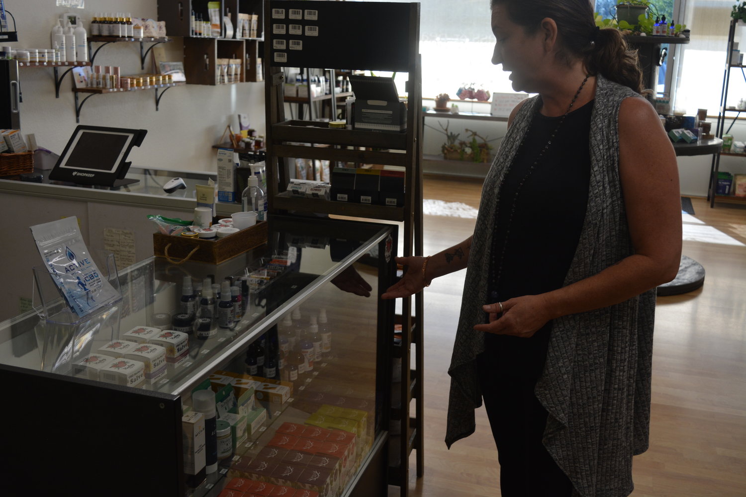 Christina Townsend shows off a case of tinctures and other CBD products at Battle Ground Natural Healing on Aug. 16.