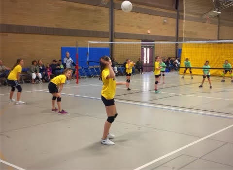 A player prepares to serve the volleyball at a game during the Battle Ground Community Education sports program.