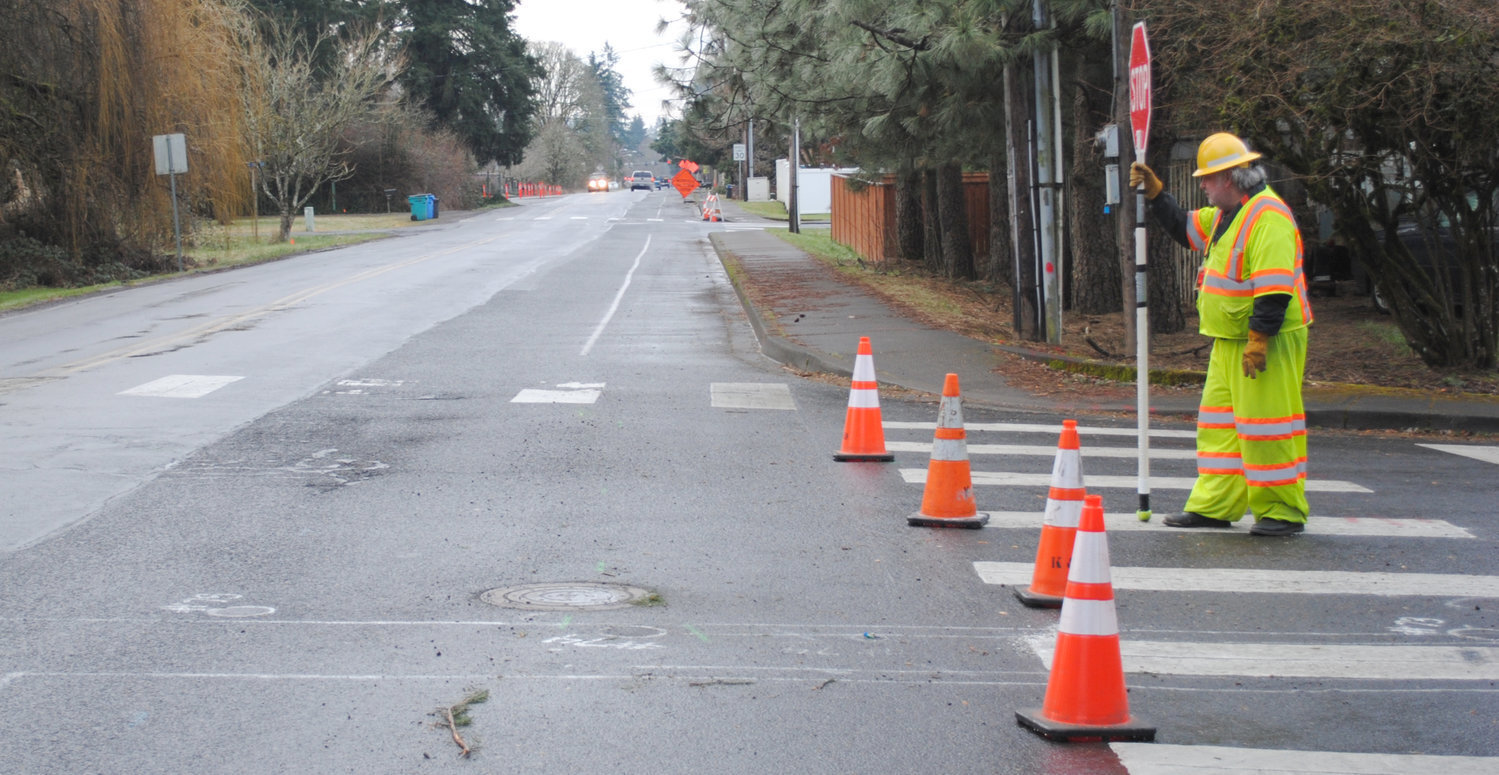 A flagger stands on South Parkway Avenue during construction in 2017 in this file photo. During a meeting with the Washington State Transportation Commission, state officials said construction jobs make up the largest percentage of industry types in Battle Ground and La Center.