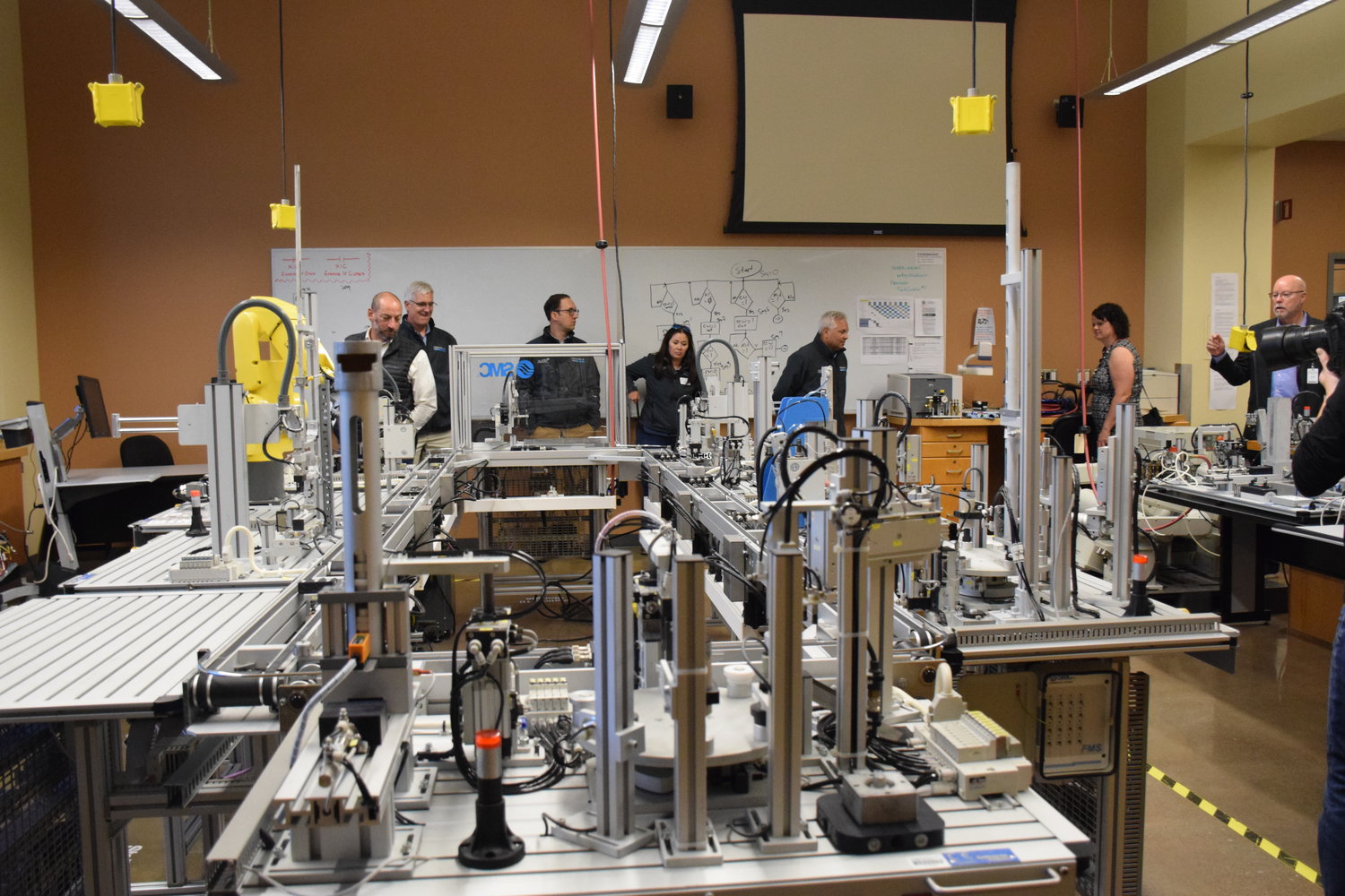 The Association of Washington Business’ Manufacturing Week bus tour participants look at one of the labs at Clark College’s Columbia Tech Center campus on Oct. 10.