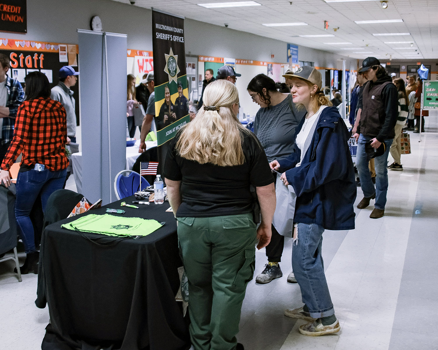 Rachel Wheeler, a recruiter for the Multnomah County Sheriff’s Office, left, speaks with a graduate of Battle Ground High School about employment opportunities during the Industry Fair on Thursday, Feb. 16.