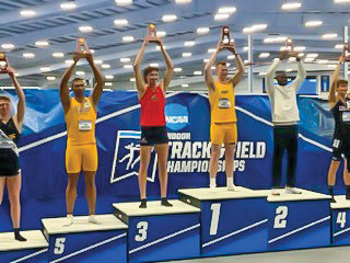 Steven Schmidt stands on the podium during the Indoor Track and Field Championships.