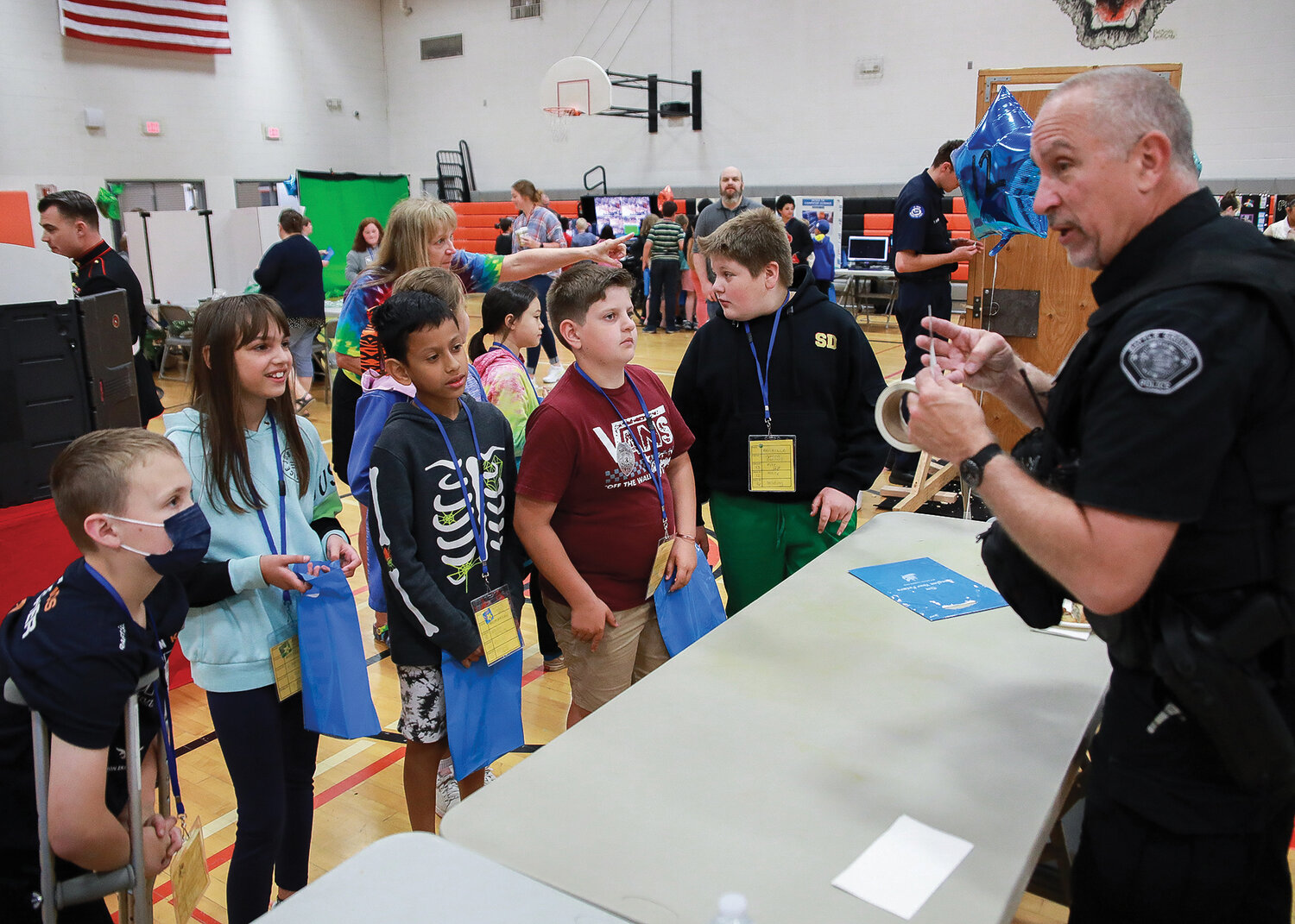 Students receive police badge stickers and information from Battle Ground’s school resource officer Phil Anderson at the fourth grade career fair at Battle Ground High School on Tuesday, May 30.