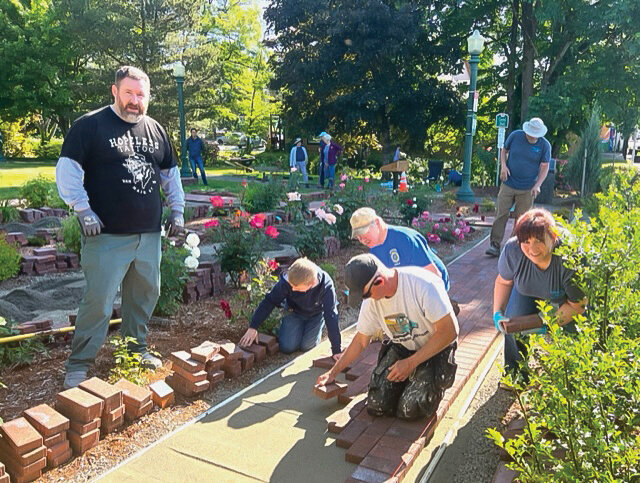 Members of the Lewis River Rotary Club and their friends and family worked to install a brick paver walkway at Central Park in Battle Ground on June 3.