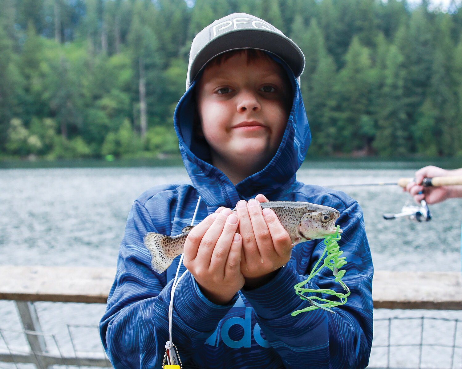 Landon Uhacz holds up a trout he caught earlier in the day at Battle Ground Lake State Park during the Columbia Springs’ fishing celebration on Saturday, June 10