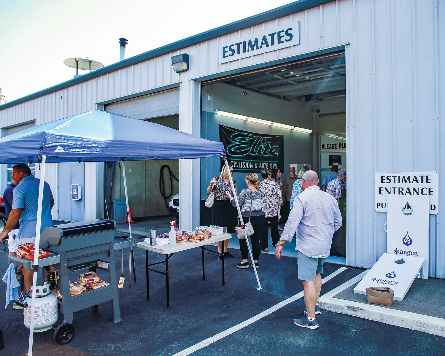 Friends and staff gather at Elite Collision Center in Battle Ground while they celebrate their 20th anniversary with a hot dog bar and other snacks and refreshments on Wednesday, June 7.