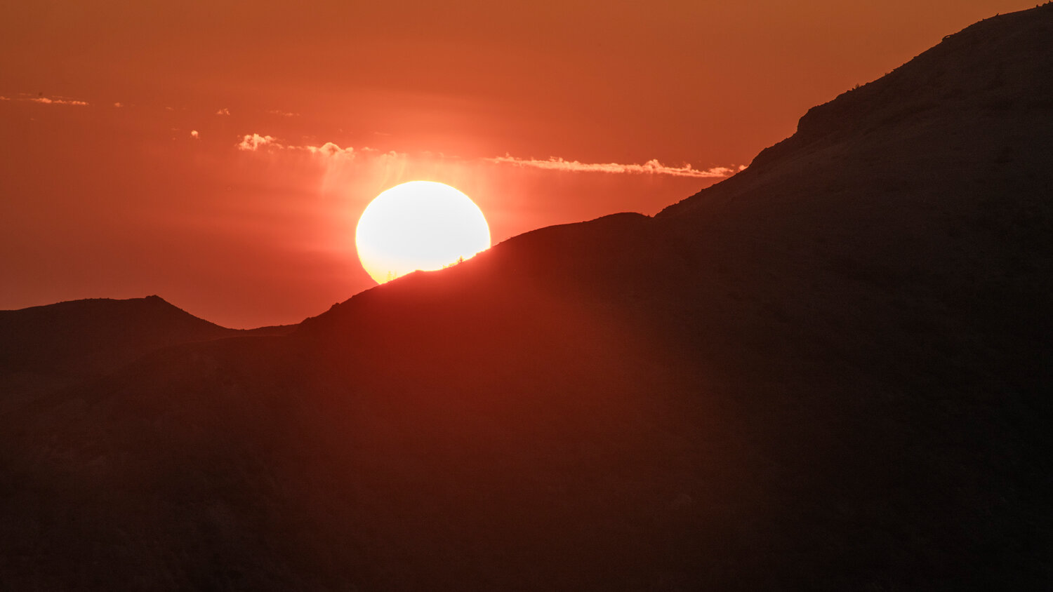 The sun dips below the horizon at sunset seen from Windy Ridge on Thursday, July 6.